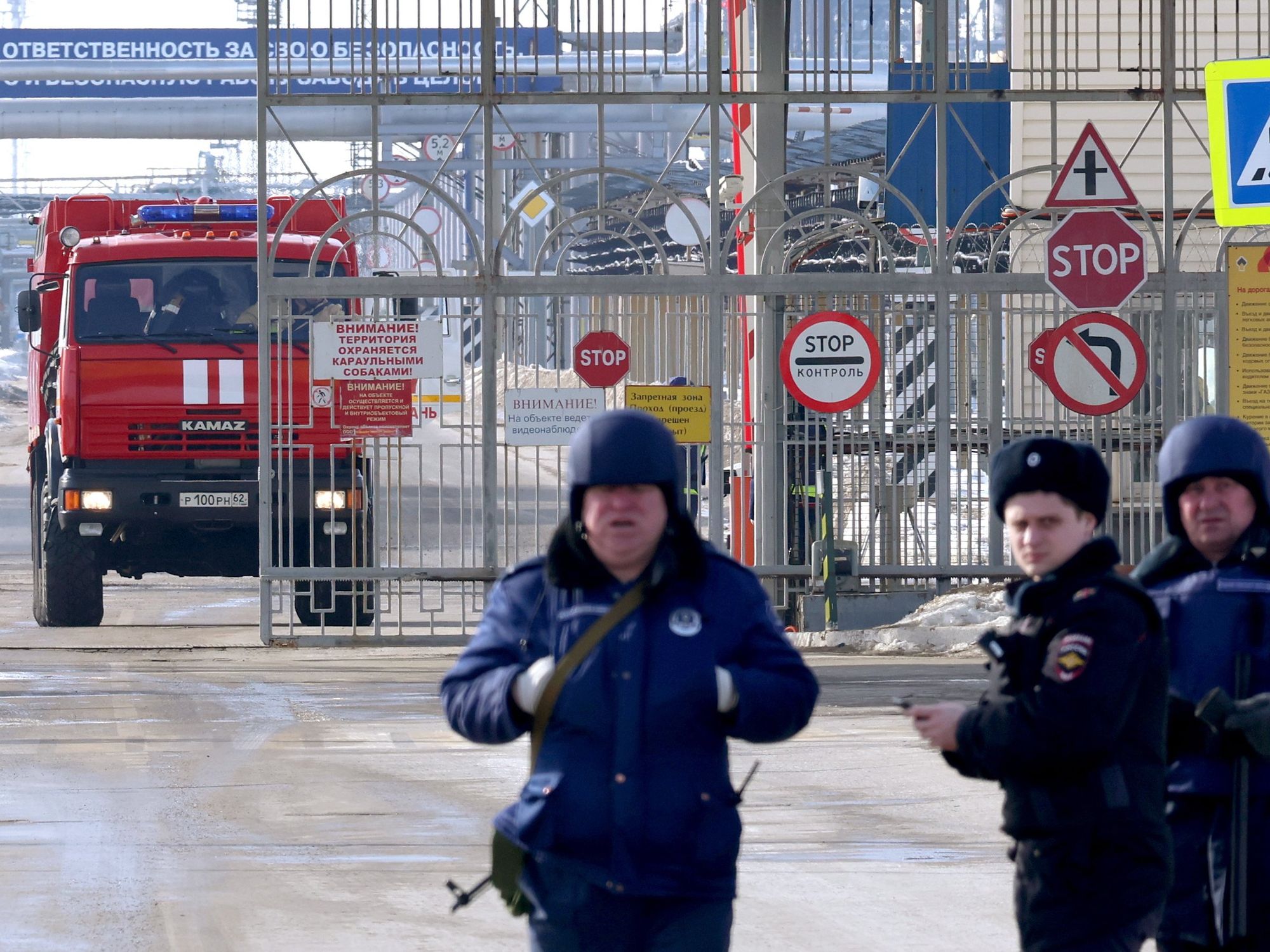 Security personal gather as a fire truck leaves the Ryazan oil refinery, in the wake of a Ukraine-led drone attack.