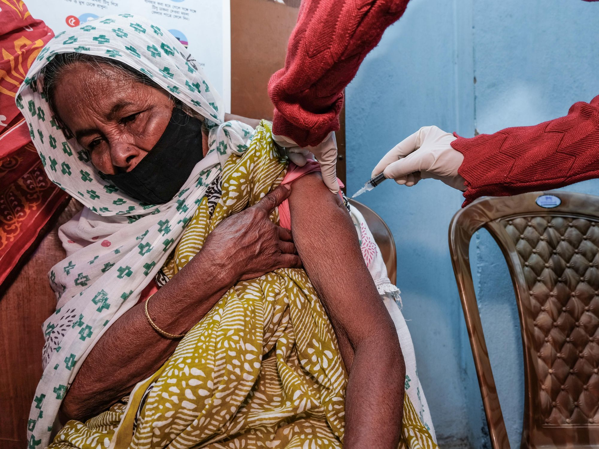 senior citizen is being administered with a third booster dose ''precautionary dose'' of coronavirus vaccine at Madhyamgram Rural Hospital