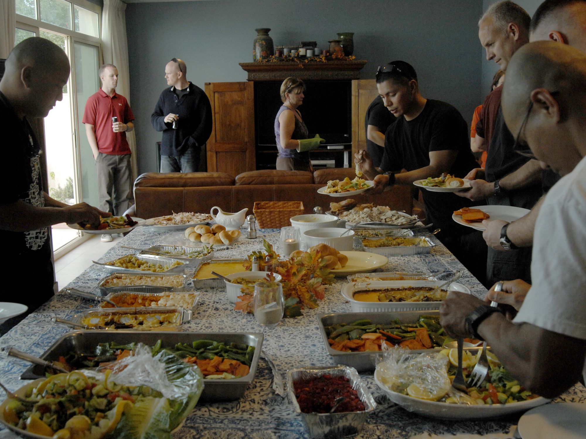 Service members from deployed locations serve themselves during a Thanksgiving meal.