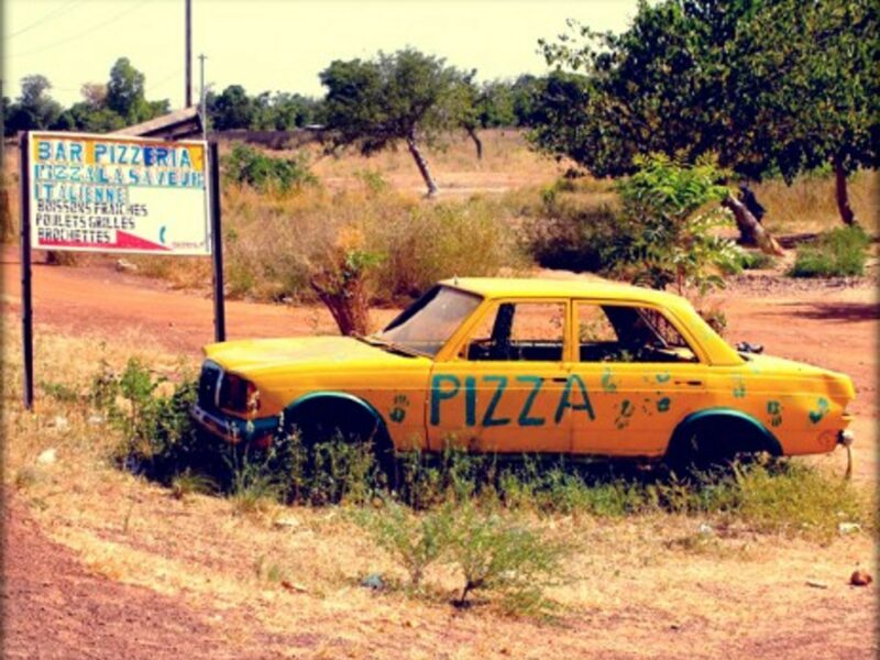 Signs for a pizzeria, a few miles from Burkina Faso's capital, Ouagadougou