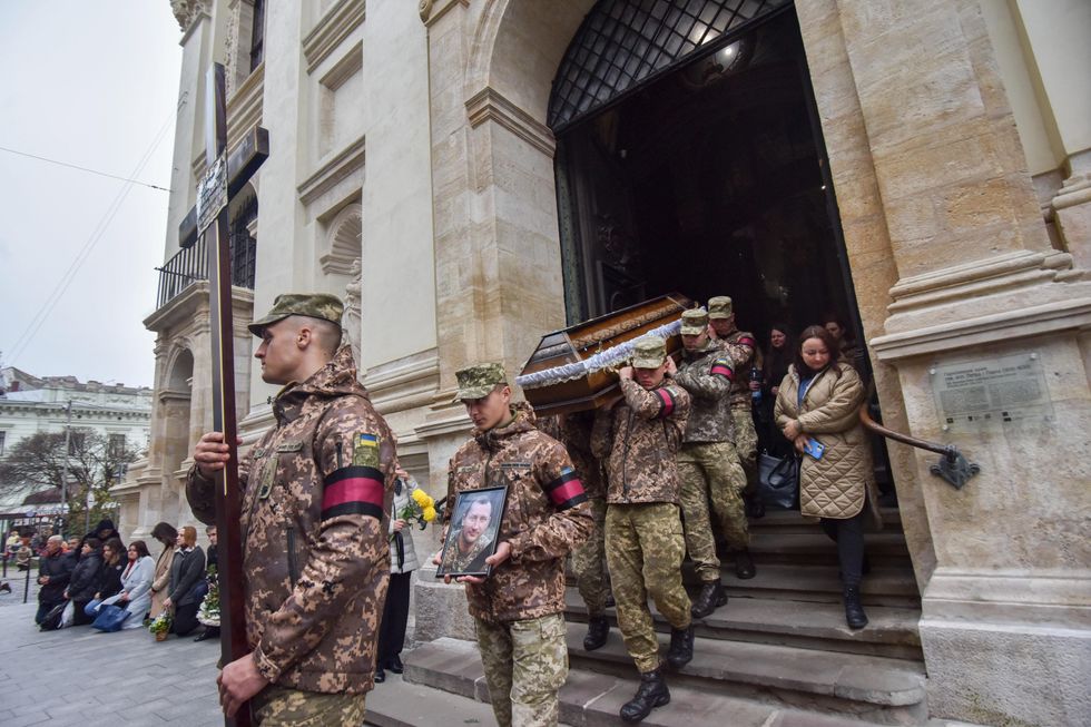 Soldiers carry coffins with the bodies of the defenders of Ukraine