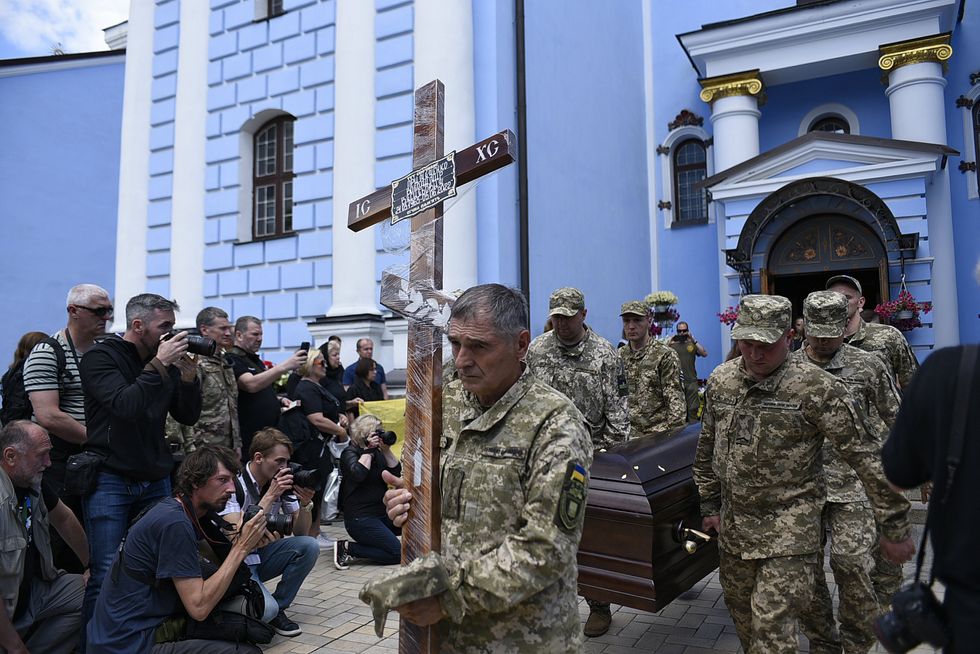 Soldiers carry the cross and the coffin during the funeral service of Ukrainian serviceman Volodymyr Prymachenko, the head of the Kyiv Department of the Ukrainian Ministry for Veterans Affairs, who died near Bakhmut, Donetsk Region, on June 5, at St Michael s Cathedral, Kyiv