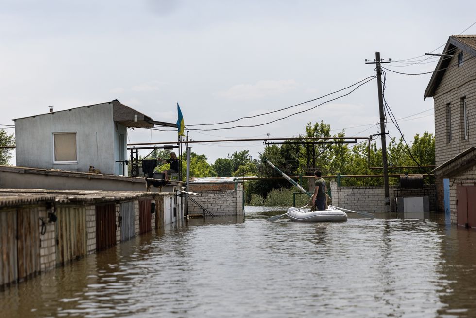 Soldiers from Ukraine's International Legion check on two men who are sleeping in a second floor room to escape the flooding in Kherson, Ukraine on June 8, 2023.​