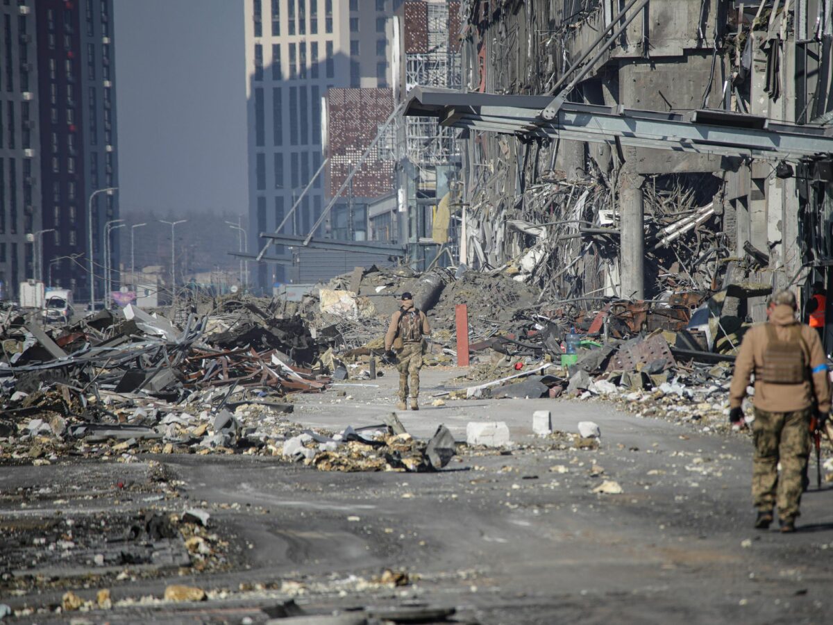 Soldiers walking by a shopping mall after it was hit by a missile strike carried out by Russian troops in the Podilskyi district of Kyiv