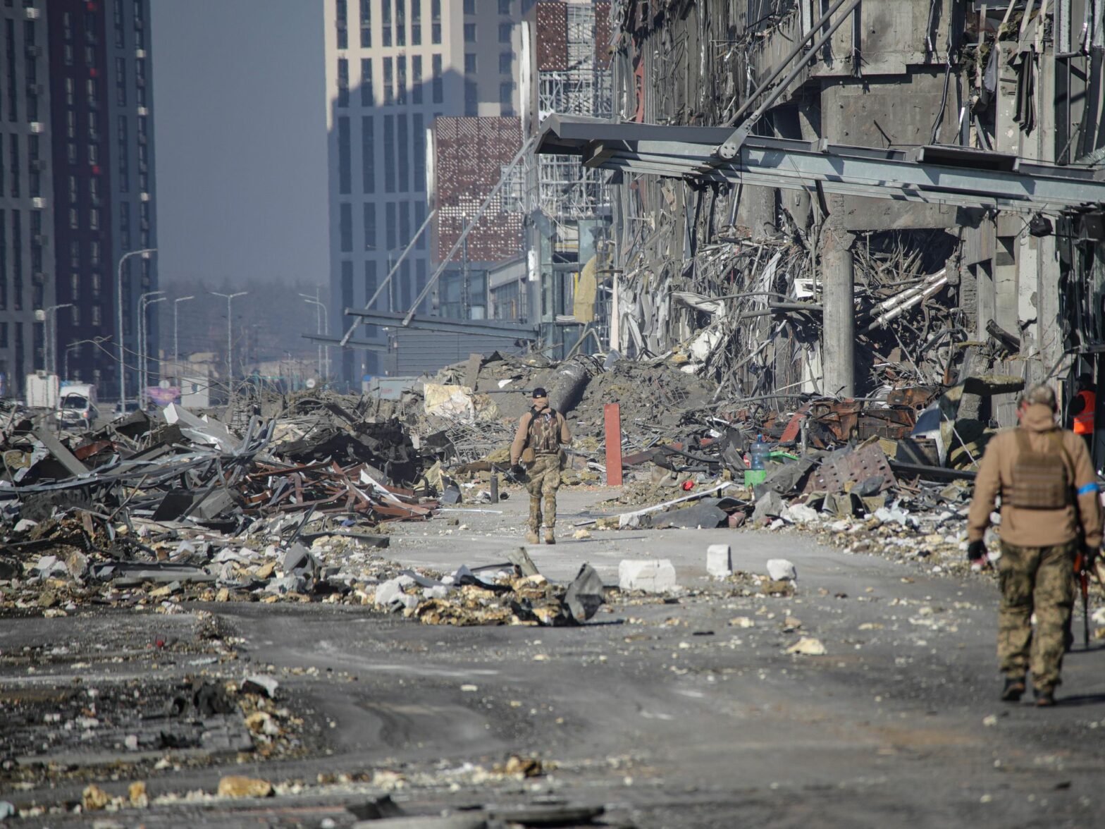 Soldiers walking by a shopping mall after it was hit by a missile strike carried out by Russian troops in the Podilskyi district of Kyiv