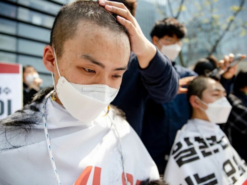 South Korean college students shave their heads in front of the Japanese embassy in Seoul to protest against Japan’s decision to release waste water from the Fukushima nuclear power plant into the sea