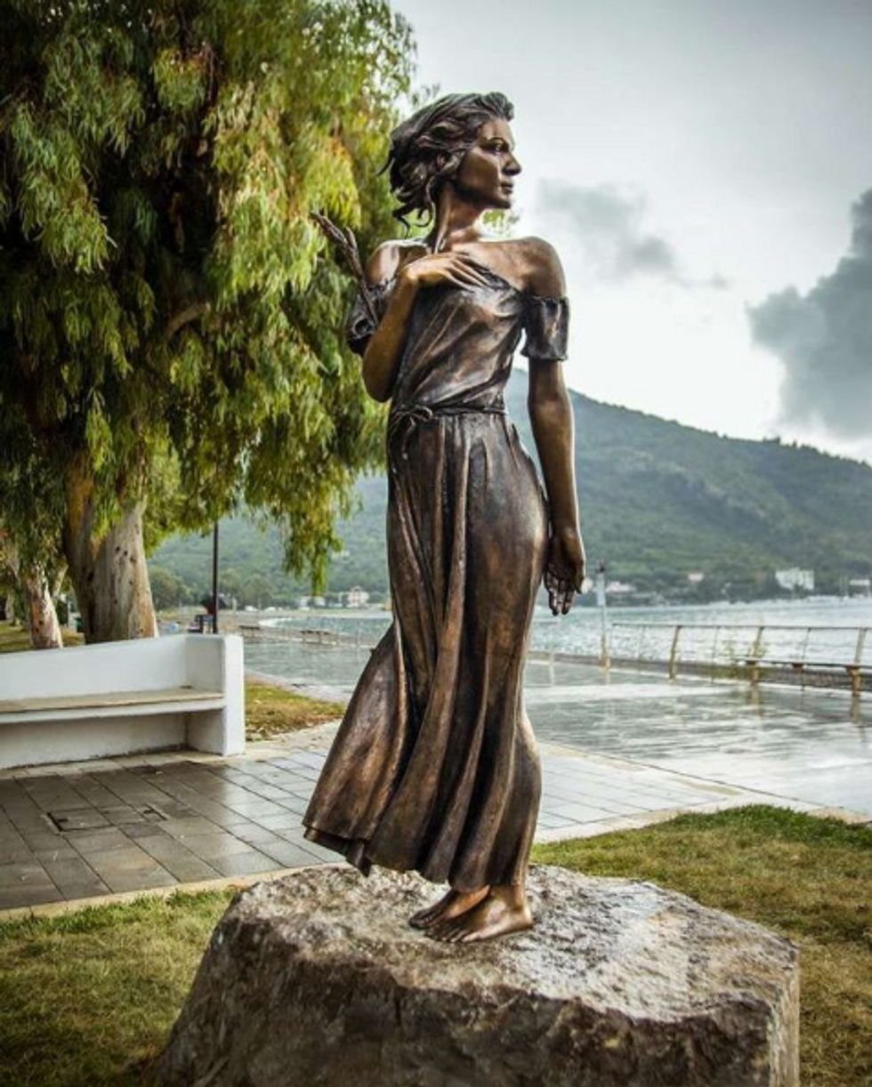Statue of a women looking over her bare shoulder to the sea