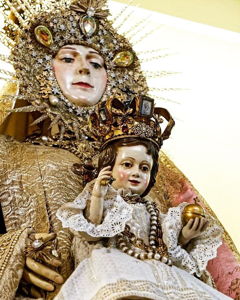 Statue of the Virgin Mary holding the Christ Child, displayed within a Paris chapel.