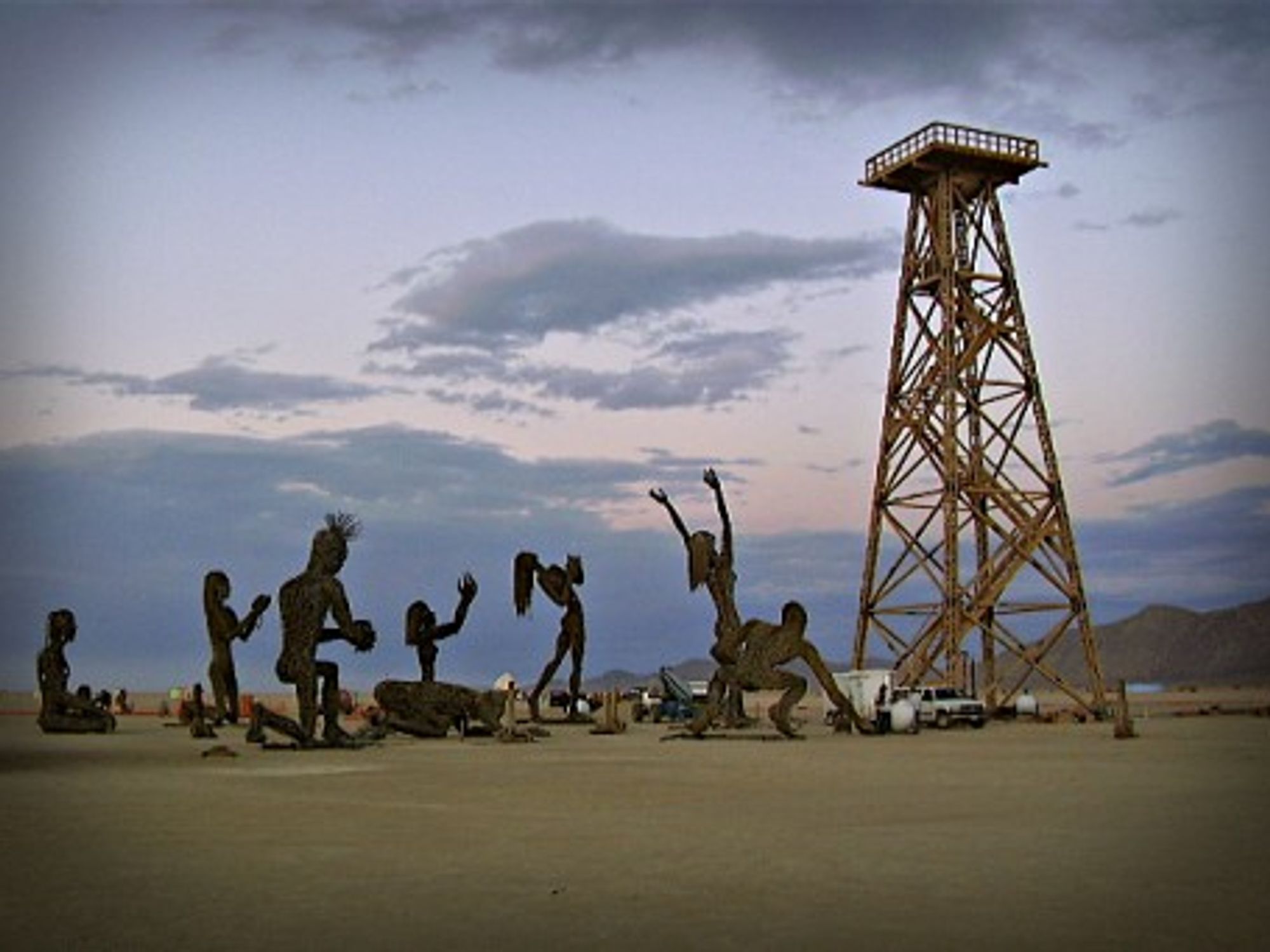 Statues of people kneeling before an oil derrick