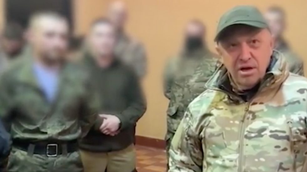 Still from a Wagner PMC recruitment video featuring owner Yevgeny Prigozhin with blurred-out soldiers in the background