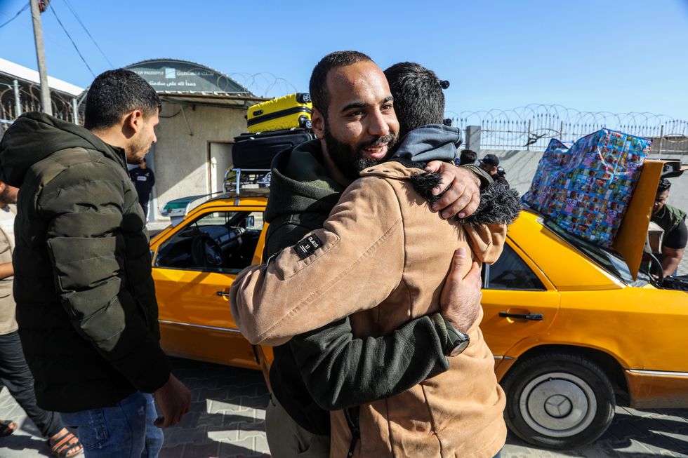 Stranded Palestinians greet each others after crossing Rafah border from Egypt.