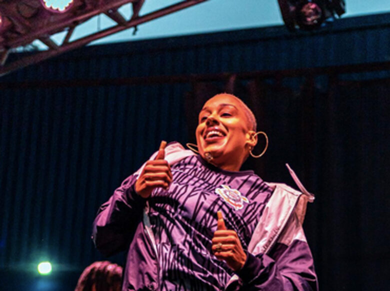 Street dancer Renatta Prado pictured in purple under warm lights.