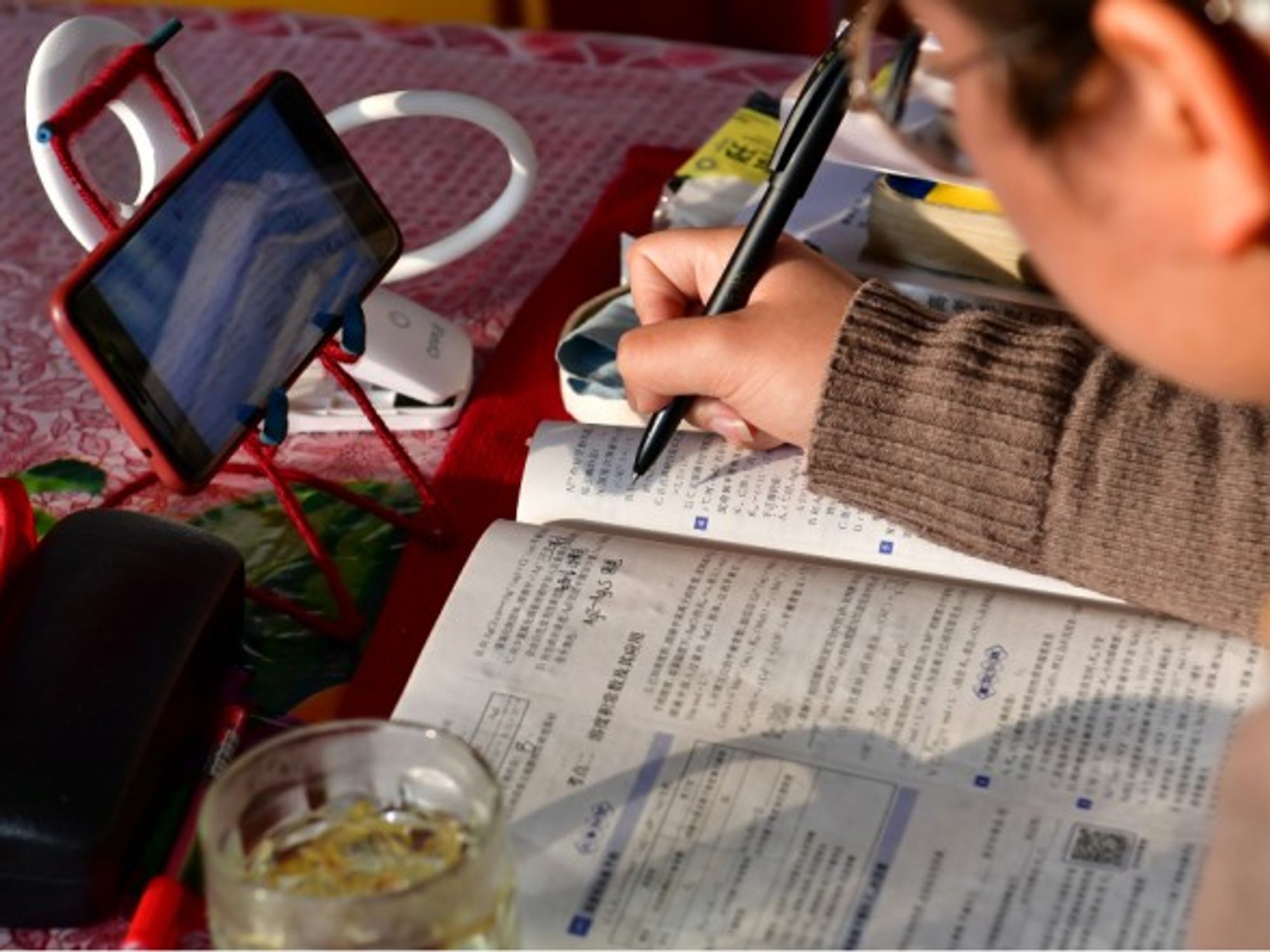 Student in China taking an online class via cellphone at home