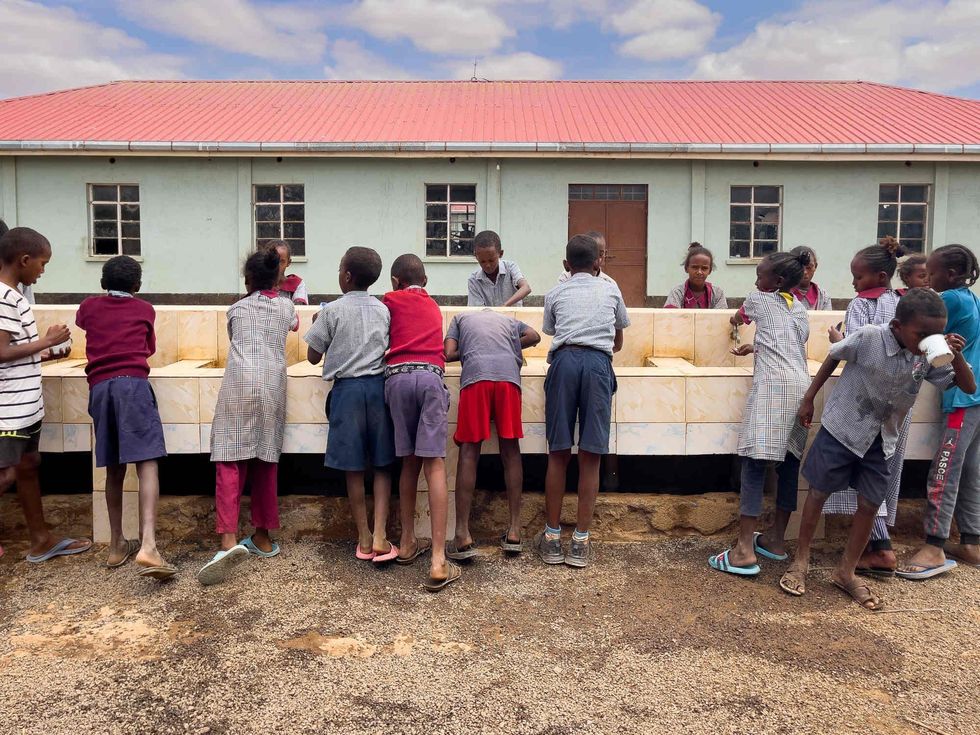 Students wash and drink outside the Tigo boarding school.