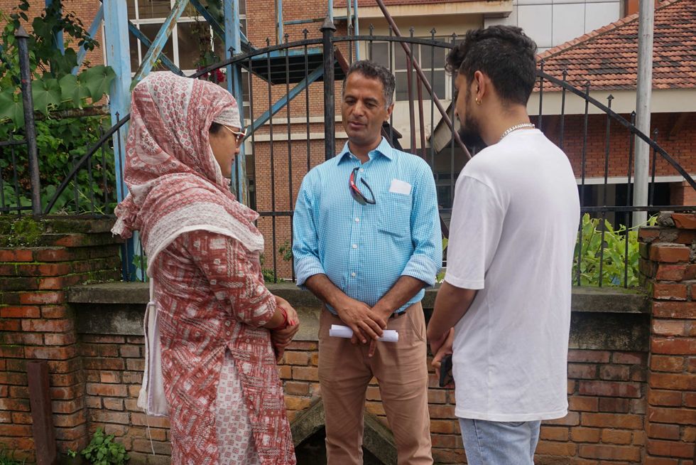 Sunil Babu Pant, center, founding director of Blue Diamond Society and the country’s first openly gay legislator, stands outside Kathmandu District Court in July 2023, alongside Maya Gurung, left, and Surendra Pandey.