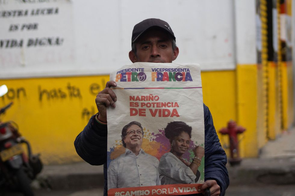 Supporter of PeA supporter of left-wing candidate Gustavo Petro holds a campaign poster during the elections on May 29, 2022tro