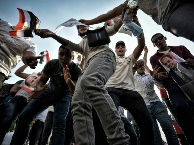 Supporters of Egyptian President Abdel Fattah al-Sisi dance and wave flags during a pro-government rally
