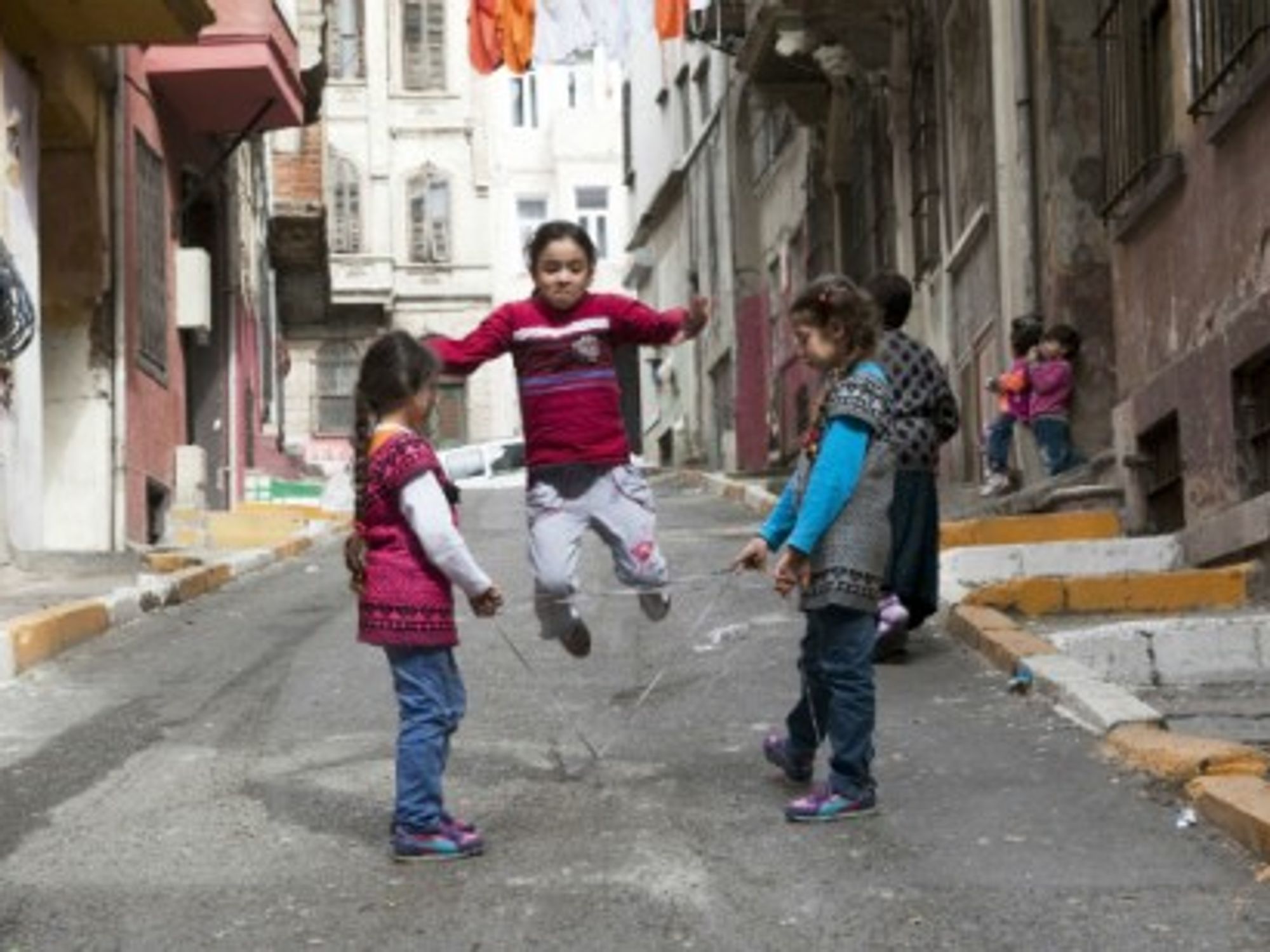 Syrian girls playing jump rope in Tarlabasi, Istanbul