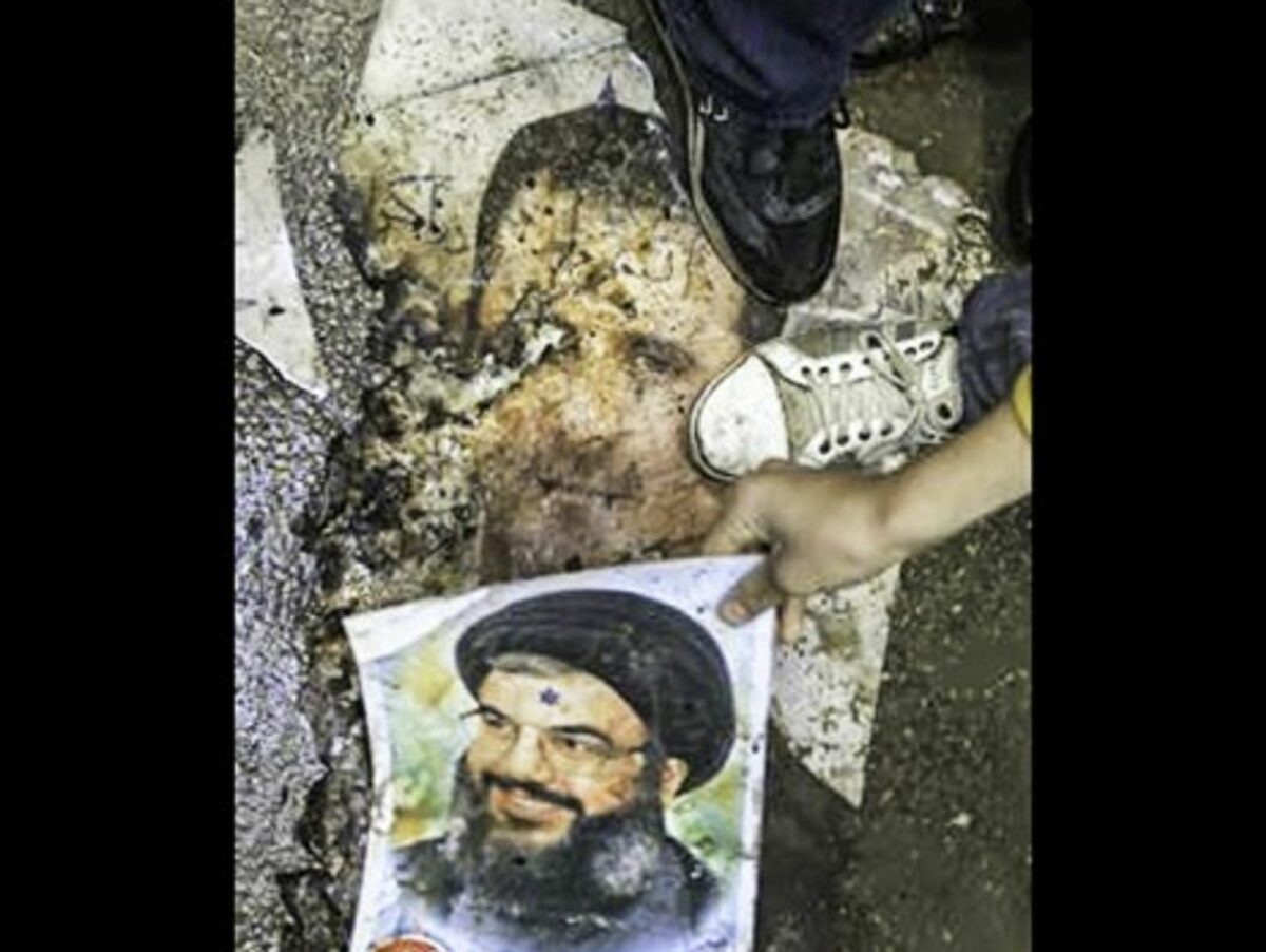 Syrian protesters step on posters of Bashar al-Assad and Hezbollah leader Hassan Nasrallah in January 2012 (FreedomHouse2)
