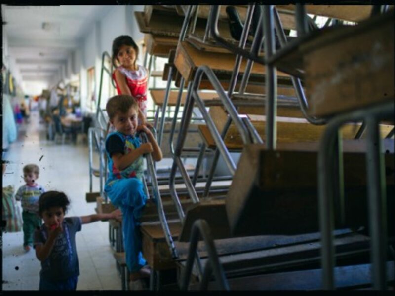 Syrian refugee children play in a school in Damascus