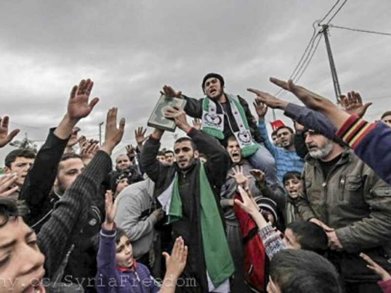 Syrian refugees center around a Koran