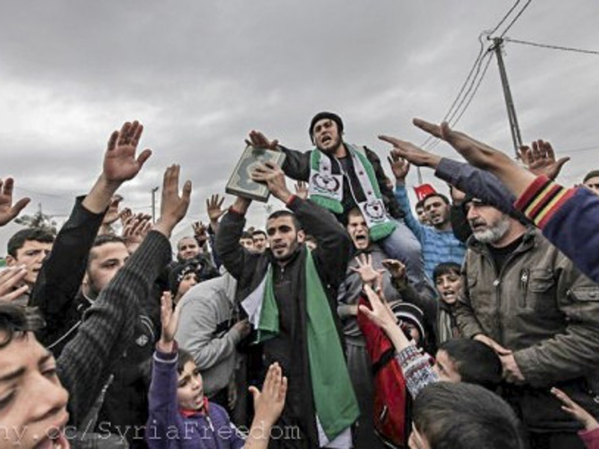 Syrian refugees center around a Koran