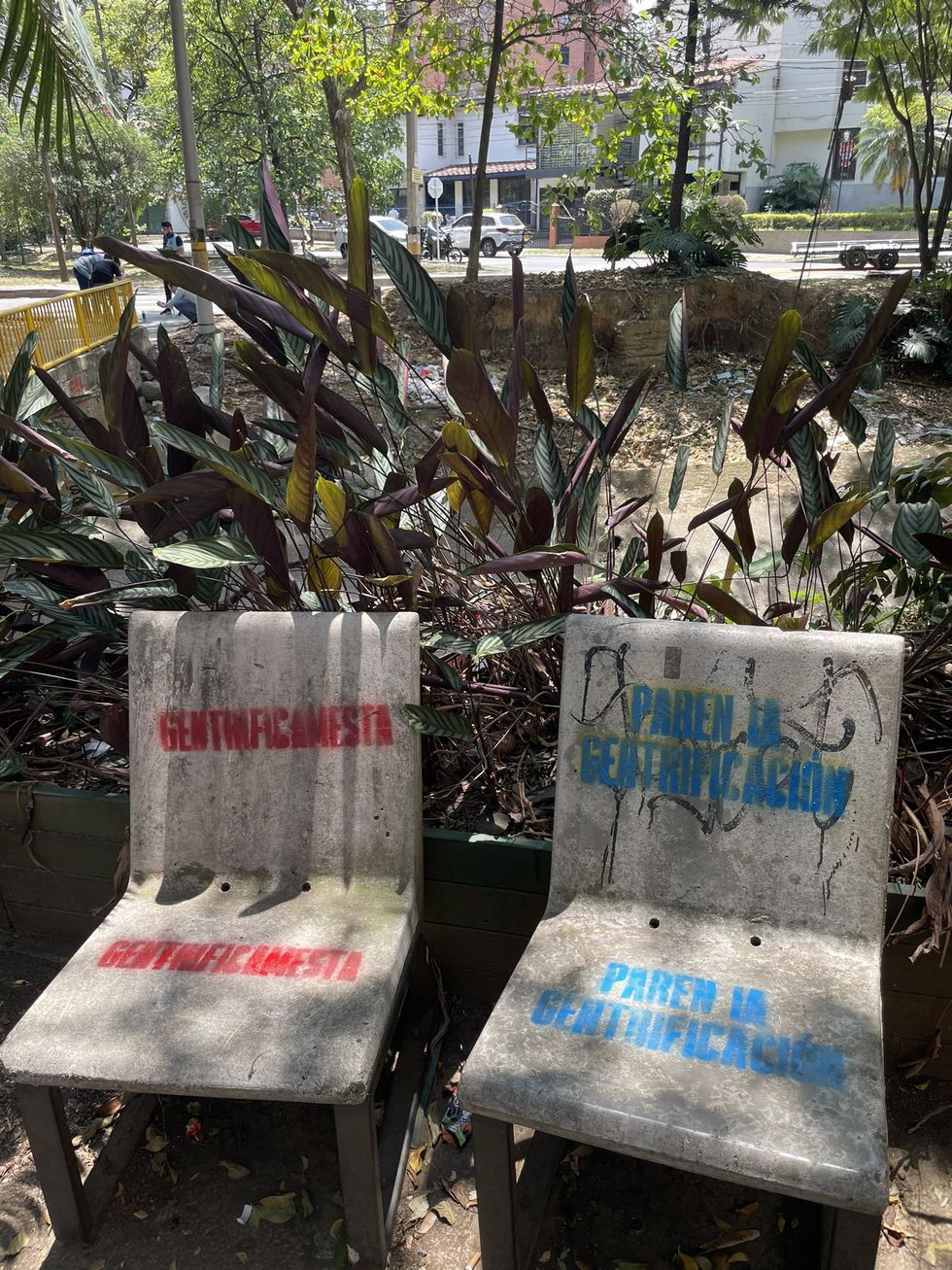 Tags against gentrification on public benches in Medellin.