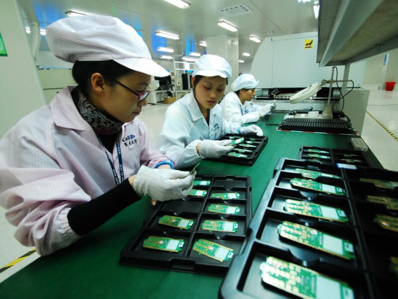 Technicians examine mobile phone chips at a manufacture plant in Jiujiang, east China's Jiangxi Province​