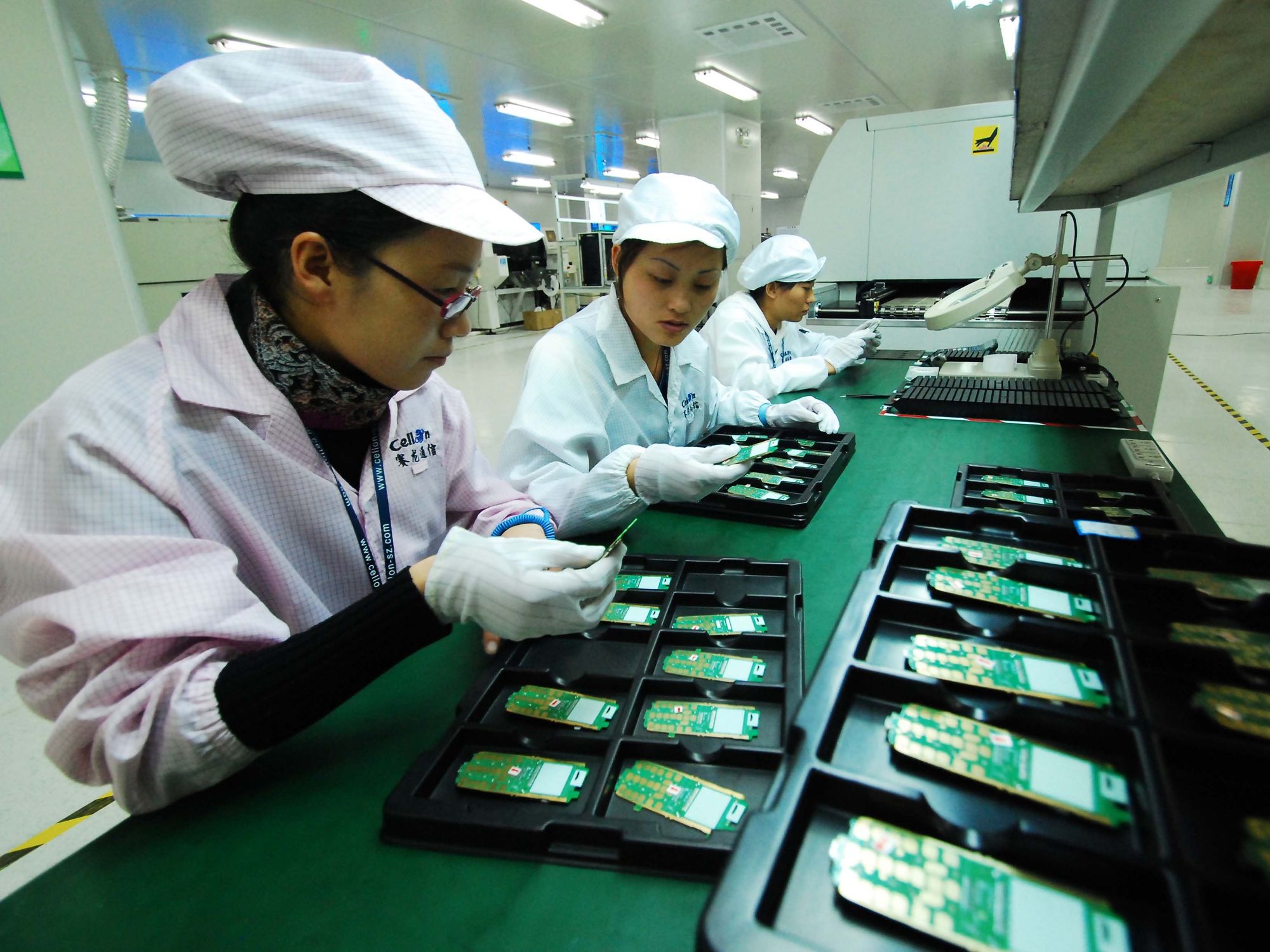 Technicians examine mobile phone chips at a manufacture plant in Jiujiang, east China's Jiangxi Province​