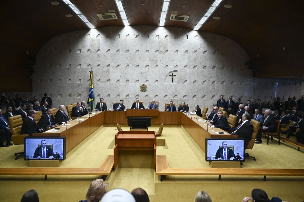 The Brazilian Supreme Court is seen in a wide angle shot that shows the horseshoe-shaped chamber, with justices and public officials seated along the main table.