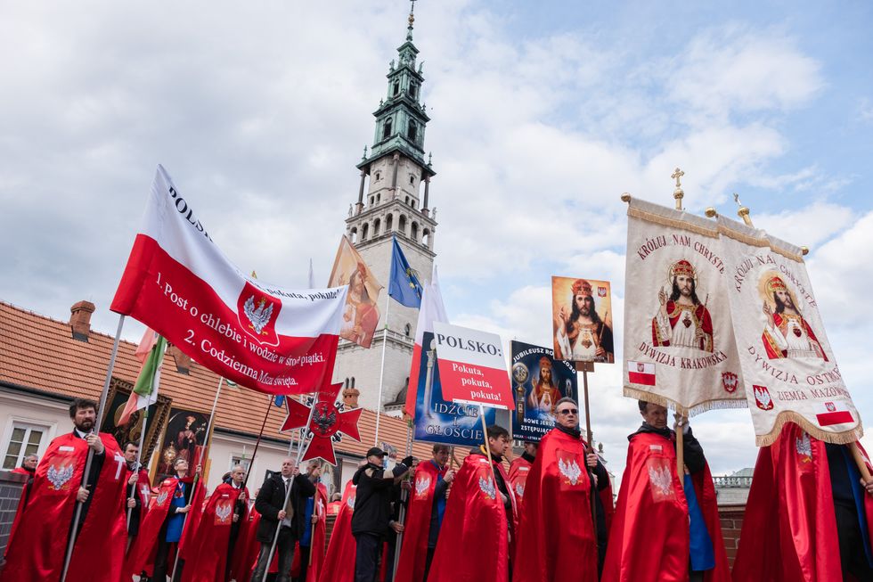 The Knights of Christ the King seen walking with the bright red pennants and banners in front of Jasna Gora monastery.