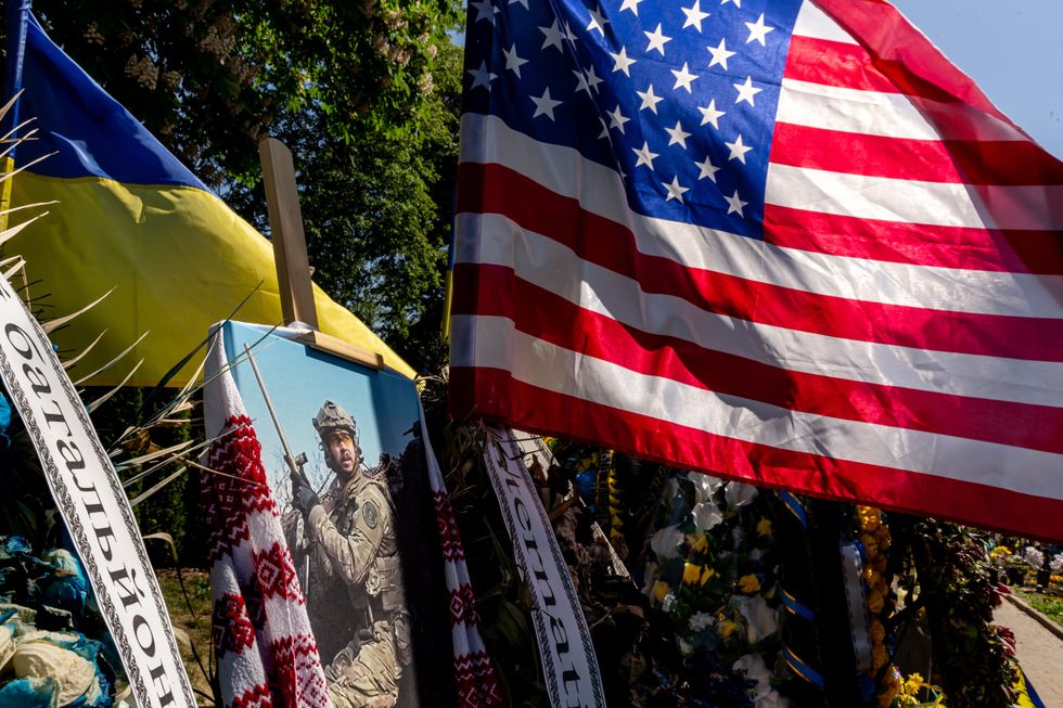 The Ukrainian and American flags fly over the grave of Chris Campbell, an American fighter in the 3rd Battalion of International Legion of Ukraine, killed in combat with Russian forces. ​
