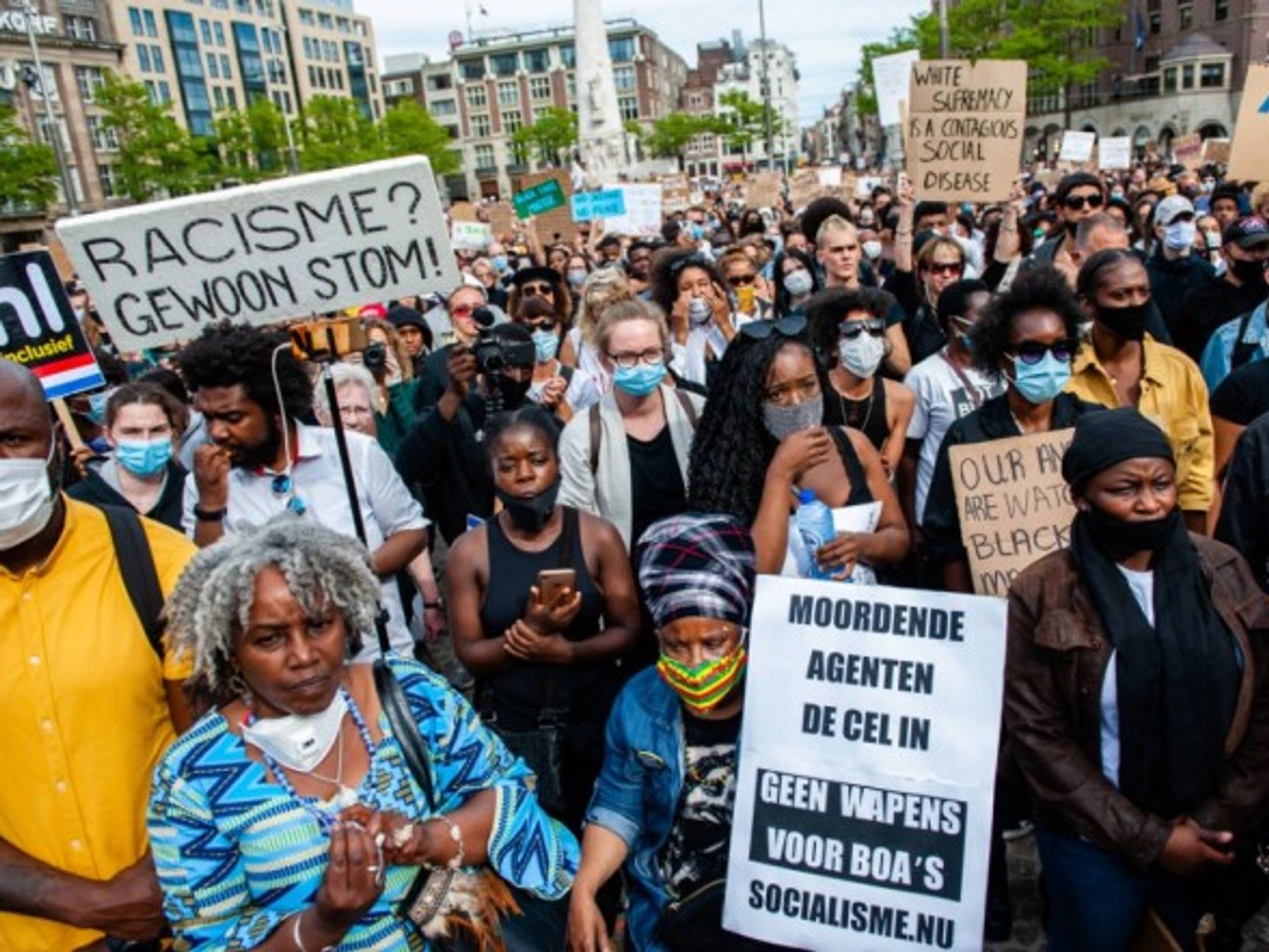 Thousands protesters are seen holding placards while listening to the speeches at the Dutch protest at Dam Square.