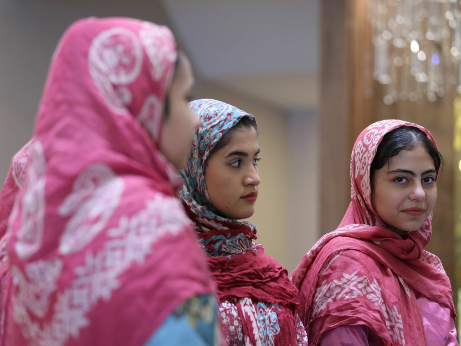 Three Iranian women wearing printed red headscarves take part in a ceremony for Aras Geopark to receive UNESCO designation in Jolfa, East Azerbaijan, Iran