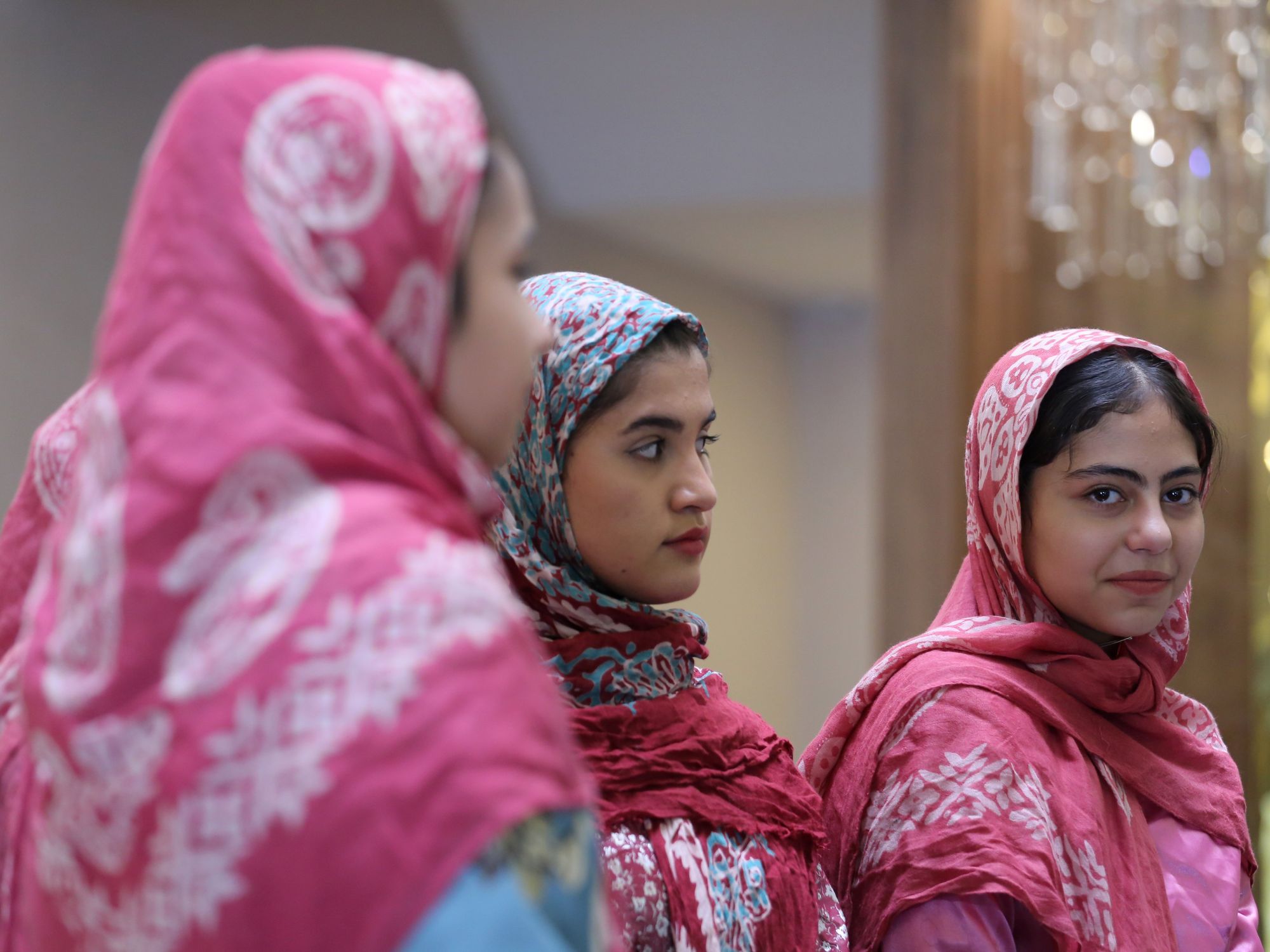 Three Iranian women wearing printed red headscarves take part in a ceremony for Aras Geopark to receive UNESCO designation in Jolfa, East Azerbaijan, Iran