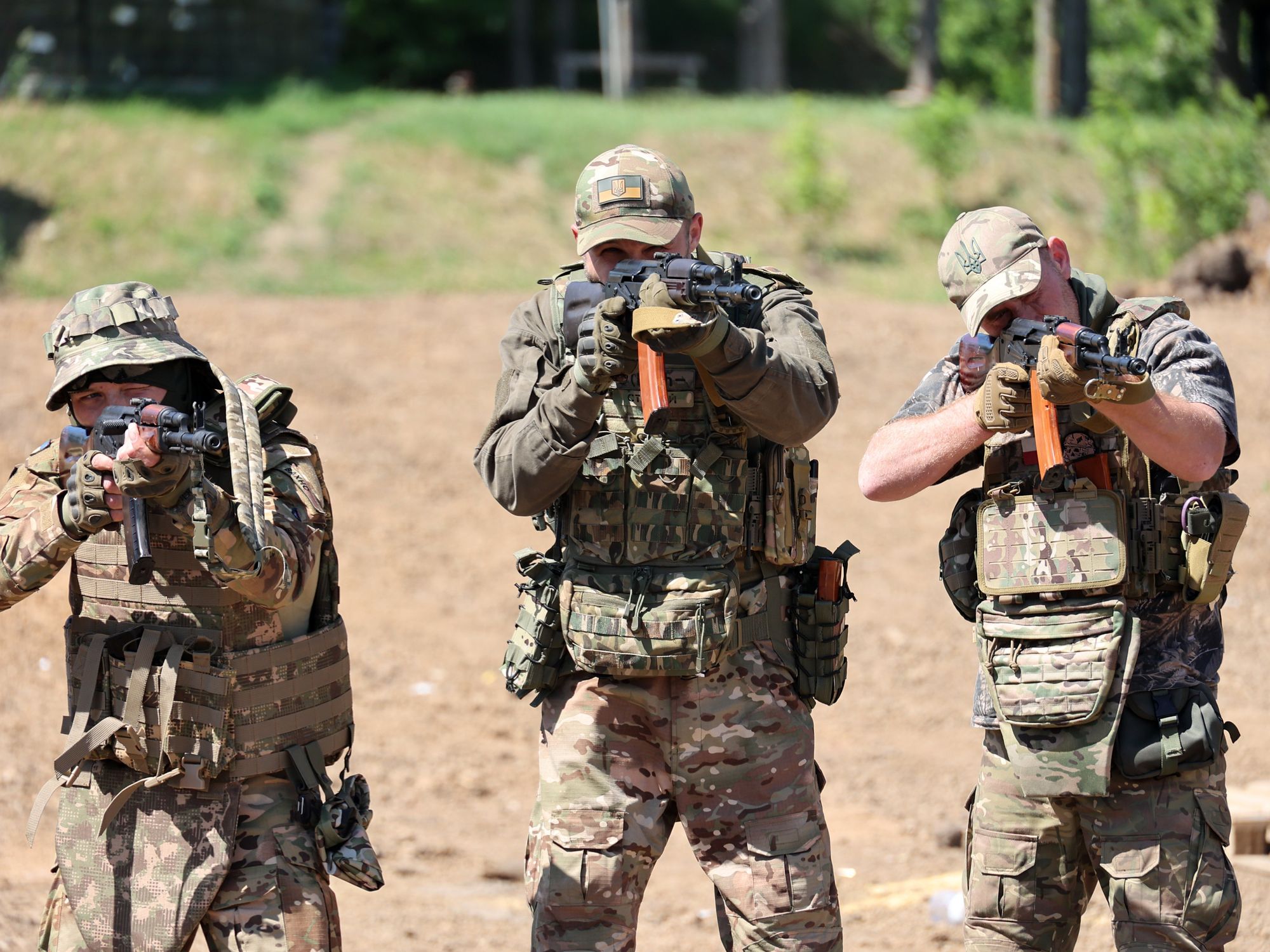 Three Ukrainian Servicemen aim their rifles towards the camera during training