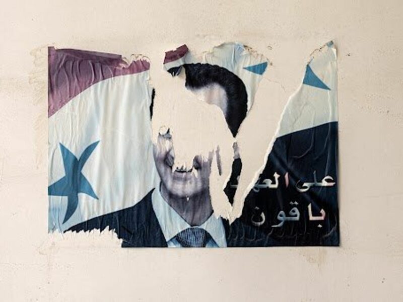 Torn poster of Bashar al-Assad near Damascus' Mezzeh prison on December 11.
