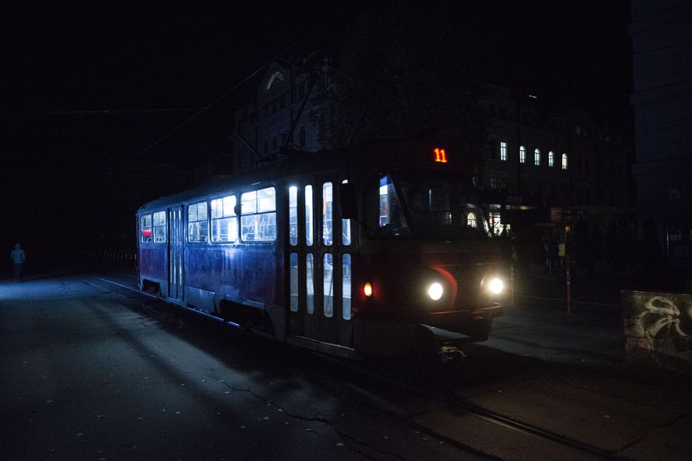 Tram on a unlit tram station in Kyiv due to blackouts