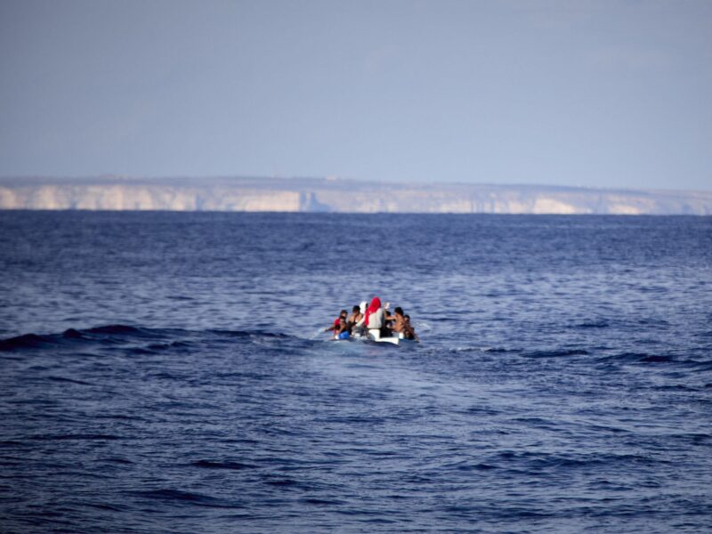 Tunisian migrants travel through the Mediterranean Sea in a small fishing boat towards the island of Lampedusa​