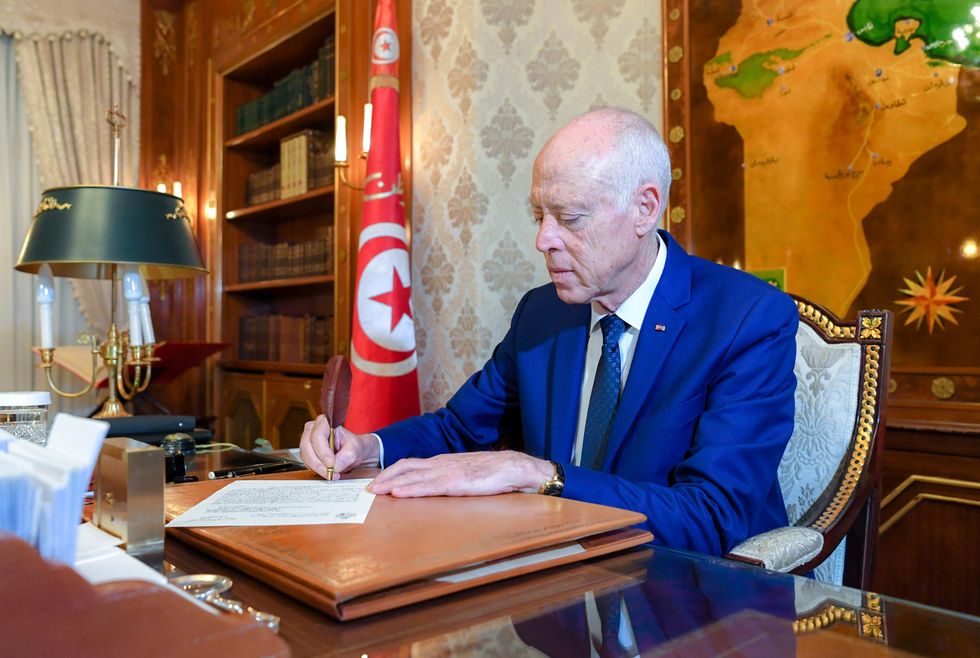 Tunisian president Kaïs Saïed sitting in his office and signing a document