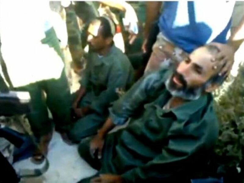 Two accused mercenaries being captured and questionned