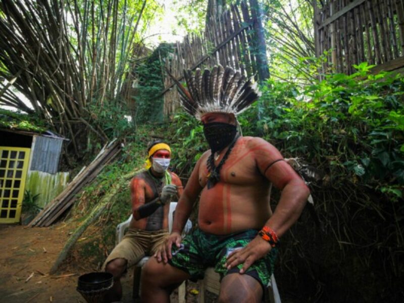 Two men of an indigenous family seen wearing face masks for protection against the coronavirus in Manaus, Brazil.