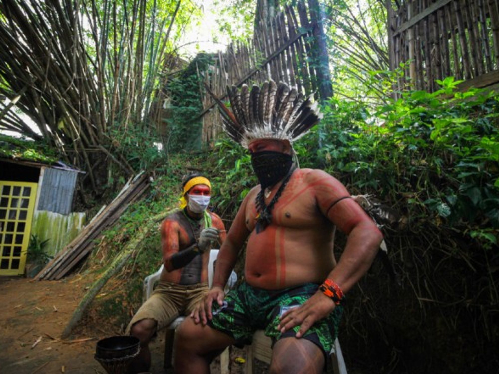 Two men of an indigenous family seen wearing face masks for protection against the coronavirus in Manaus, Brazil.