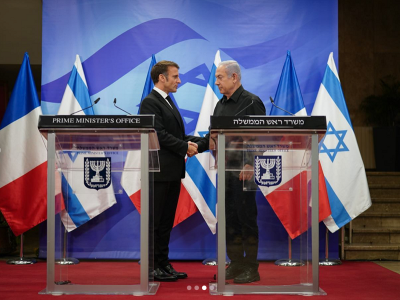 two men shake hands behind podiums