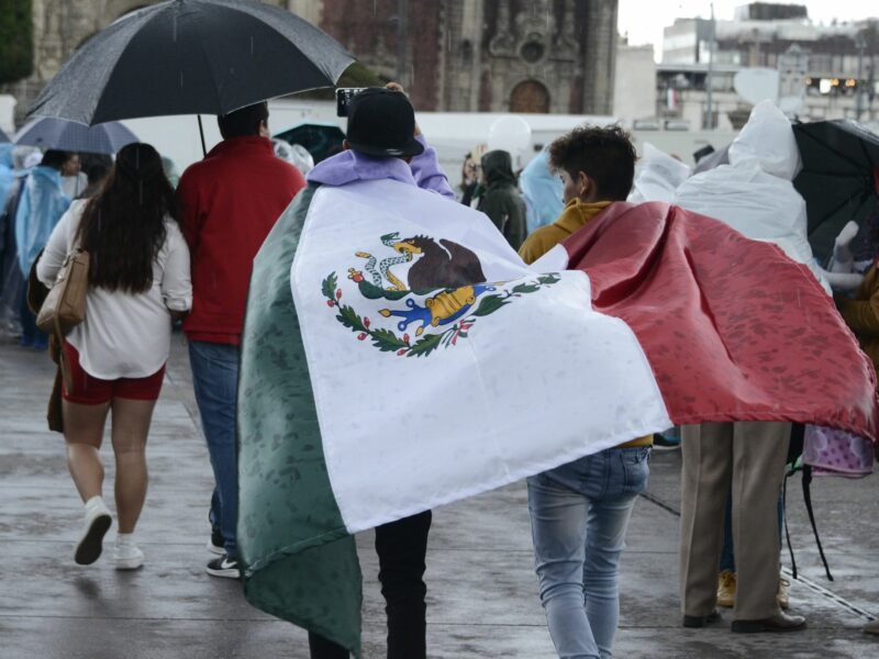 Two people wearing the Mexican flag during the celebrations of the 212th Anniversary of Mexico's Independence Day in Mexico City, Mexico.