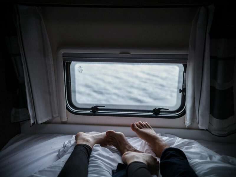 Two persons lying on a white bed.