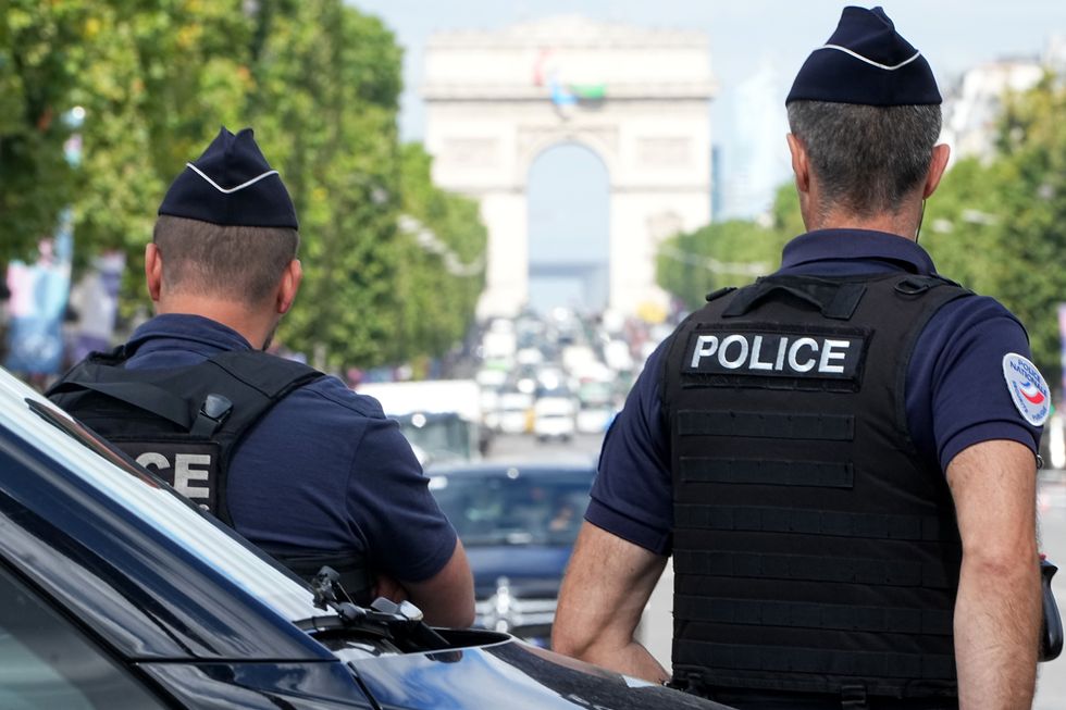 Two police officers watch the traffic around the Arc de Triomphe in Paris.