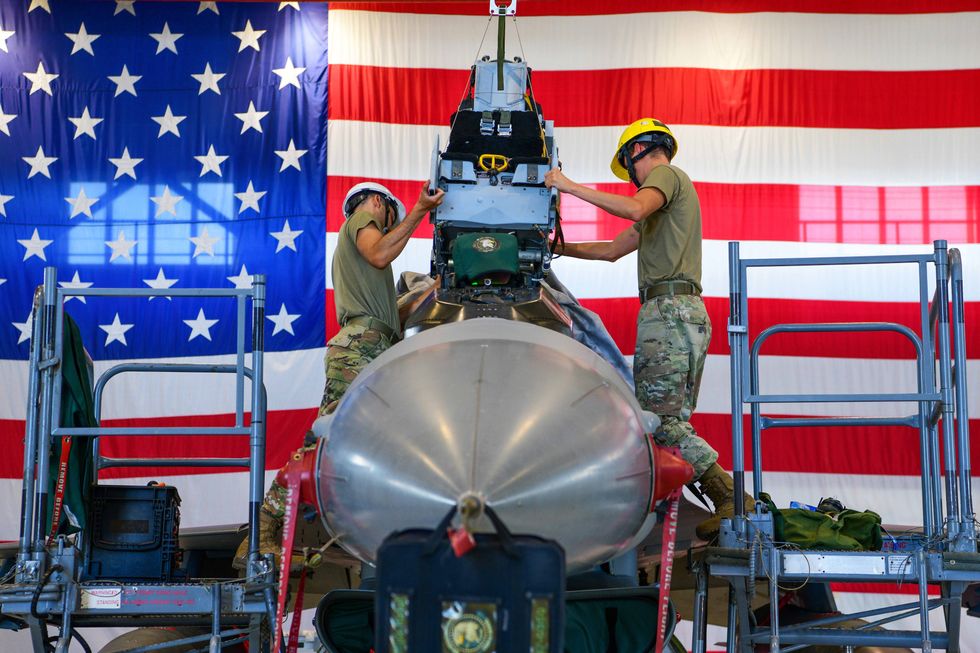 U.S. Airmen from the 31st Maintenance Squadron Egress journeymen, put a seat into an F-16 Fighting Falcon at Aviano Air Base, Italy, August. 11, 2022.