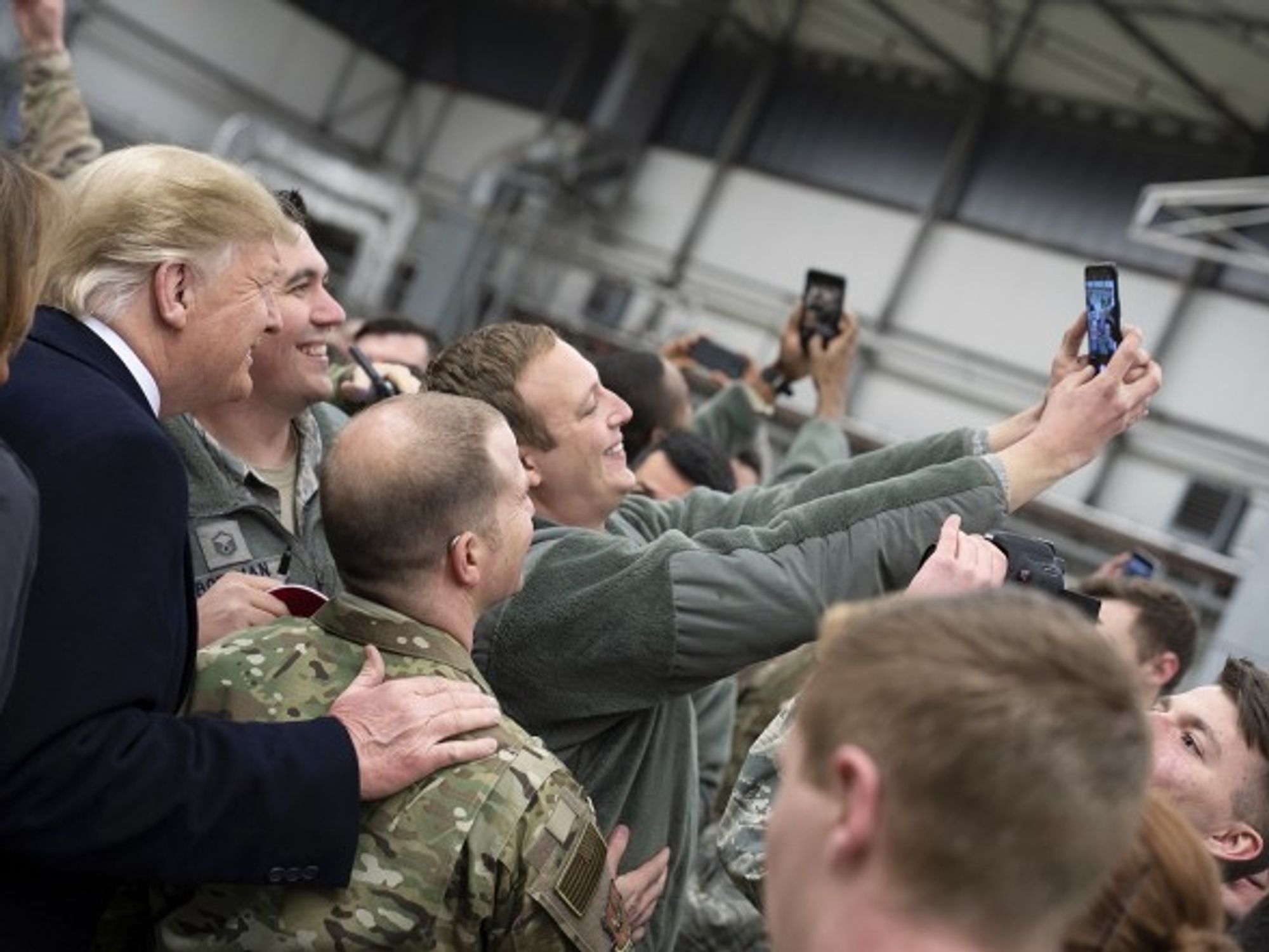 U.S. President Donald Trump takes selfies with U.S. service members during stop-over at Ramstein Air Force Base in Germany.