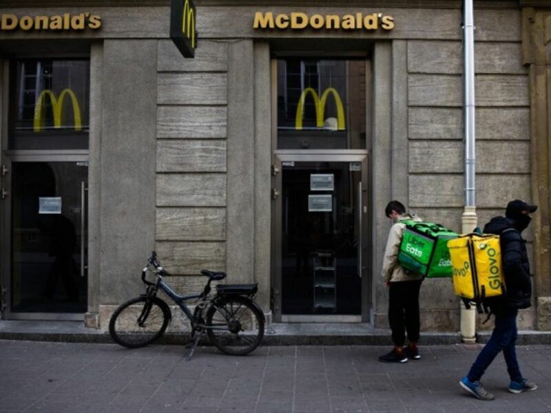 UberEats and Glovo workers wait for McDonald's meals to deliver to their costumers.